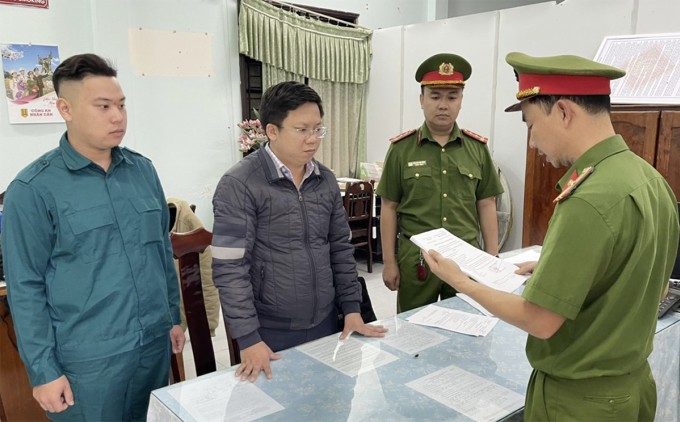 Hà Hải Đăng (đeo kính) nghe đọc lệnh bắt. Ảnh: Công an Quảng Nam